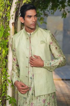 Mint green sleeveless Nehru jacket with stitchline thread embroidery in stripe pattern. Paired with floral print pleated kurta and churidar. - Aza Fashions Fitted Green Nehru Jacket For Spring, Green Fitted Nehru Jacket For Spring, Fitted Green Bandhgala For Spring, Spring Green Fitted Bandhgala, Festive Embroidered Pista Green Nehru Jacket, Festive Green Nehru Jacket, Fitted Green Nehru Jacket With Floral Embroidery, Designer Embroidered Green Nehru Jacket, Green Sleeveless Fitted Nehru Jacket