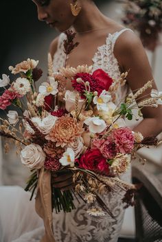 a woman holding a bouquet of flowers in her hands