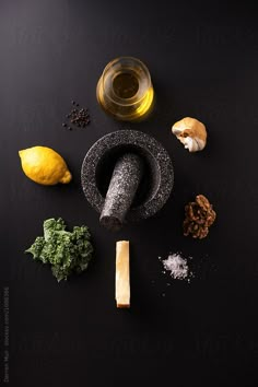 an assortment of ingredients including lemons, garlic and other items on a black surface