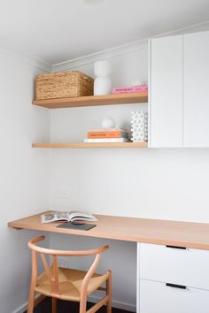 a desk and chair in a small room with shelves on the wall above it, next to a book shelf