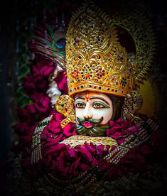 a close up of a statue of a person wearing a crown and holding a pipe