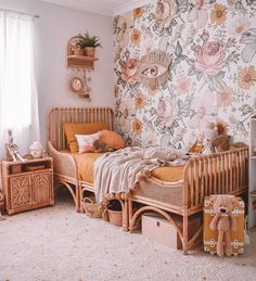 a child's bedroom with floral wallpaper and wooden furniture