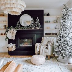 a living room decorated for christmas with white and silver decorations on the mantels