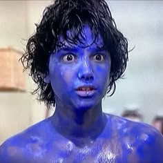 a man with blue paint on his face and chest