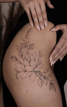 a woman's thigh with a flower tattoo on it