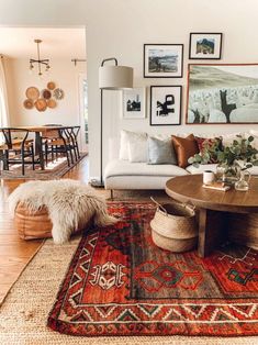 a living room filled with lots of furniture and pictures on the wall above it's coffee table