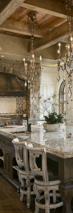 a large kitchen with marble counter tops and chandeliers