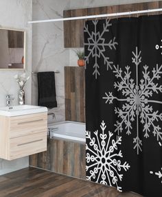 a bathroom decorated with black and white snowflakes on the shower curtain next to a bathtub