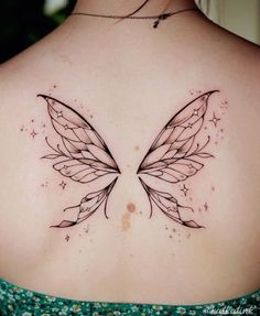 the back of a woman's shoulder with an intricate butterfly tattoo on her chest