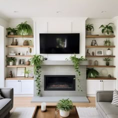 a living room filled with furniture and a flat screen tv mounted on the wall above a fire place