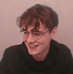 a young man with glasses smiling for the camera