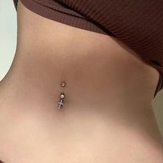 a woman's stomach with a tiny cross on it