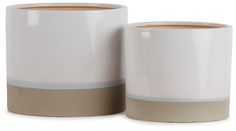 two coffee mugs sitting next to each other on a white surface with brown trim