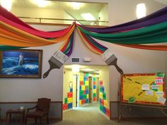 the hallway is decorated with rainbow colored streamers and pictures on the wall above them