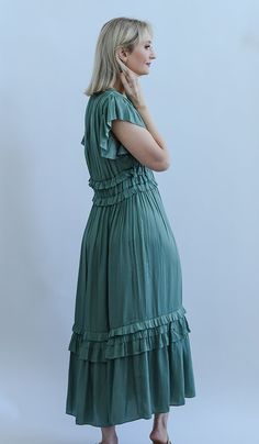 The standout ruffled satin midi dress is the perfect dress for all year long! This midi dress is detailed with flutter sleeves, a v-neckline, and elastic waist, ruffled detailed around the waist and lower hem and a gorgeous teal green satin fabric. You can pair it with a jean jacket and sandals to have a more casual look. Or throw on your favorite heels and statement earrings to dress it up. No matter where you go, you will be catching eyes in this beautiful teal green satin dress! - Fits true t V-neck Midi Dress With Ruffle Hem In Rayon, Rayon Midi Dress With Ruffle Hem And V-neck, Rayon V-neck Midi Dress With Ruffle Hem, V-neck Rayon Midi Dress With Ruffle Hem, Green Midi Ruffle Dress, Flowy Green Rayon Midi Dress, Green Midi-length Ruffle Dress, Flowy Green Ruched Midi Dress, Green Midi Dress With Ruffle Hem