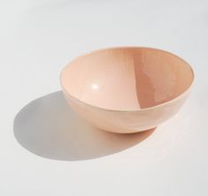 a pink bowl sitting on top of a white table