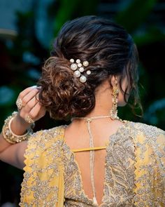 a woman wearing a yellow dress with pearls in her hair and an intricate head piece