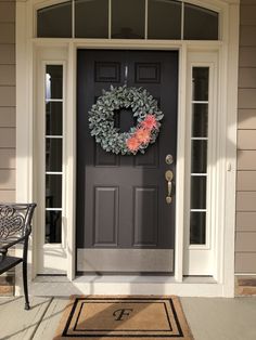 a black front door with a wreath on it