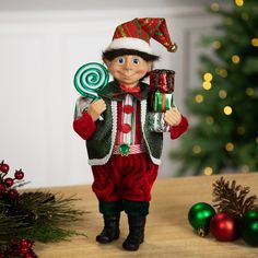 a christmas elf figurine holding a candy cane