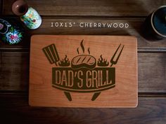 a wooden cutting board with the words dad's grill on it