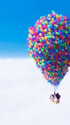 a house is floating in the air with colorful balls attached to it's sides