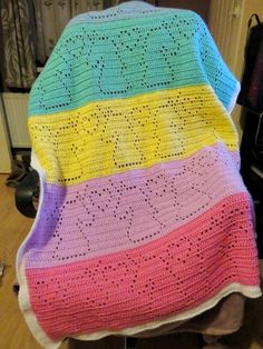 a crocheted blanket sitting on top of a chair