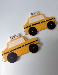 two yellow school bus shaped magnets sitting on top of a white table next to each other