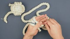 someone crocheting the ends of a rope to make a knot for an ornament