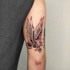 a man with a tattoo on his arm has an eagle and skull in the middle