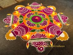 a colorful rangdi design with candles on the ground