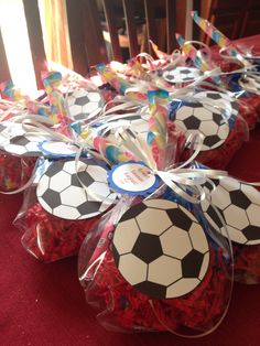 soccer themed cupcakes in plastic wrappers on a red tablecloth with streamers