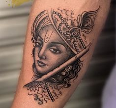 a woman's face with a knife in her head tattoo on the left arm