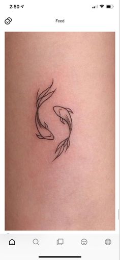 a small tattoo on the side of a woman's thigh, with two fish in it