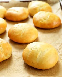 freshly baked bread rolls lined up on a baking sheet