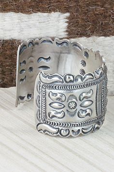 This sterling silver bracelet was made by Navajo silversmith Eugene Charley. The inside is signed and stamped sterling.Size: 5 3/4" (will fit up to a 7" wrist)Gap: 1 1/4"Width: 1 1/2"Free shipping on all orders! We ship with USPS and always include tracking. All orders ship within a day of payment.Returns are accepted up to 30 days after you receive your order. Just send us a message. Our shop offers cash back or store credit. The item must be returned in new condition. Western Sterling Silver Cuff Bracelet With Concho, Handmade Western Sterling Silver Cuff Bracelet, Southwestern Oxidized Bracelet, Artisan Sterling Silver Concho Cuff Bracelet, Southwestern Stamped 925 Cuff Bangle Bracelet, Artisan Silver Concho Cuff Bracelet, Unique Stamped Sterling Silver Collectible Bracelet, Western Sterling Silver Cuff Bracelet Gift, Western Silver Cuff Bracelet With Concho