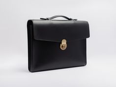 Mens leather briefcase in a classic yet modern style, to treasure for years to come. Brass lock closure, top handle, envelope style flap.Elegant, rich Italian full grain veg tanned leather (Buttero) exterior, with optional lined interior. Luxury designer quality, handmade in the US with the finest materials sourced from Italy and France. Hand stitched and hand painted edges.Buttero leather has a smooth finish with a slight sheen, and will patina beautifully with use and time, creating a bag uniq Formal Briefcase With Palladium Hardware, Palladium Hardware Briefcase For Work, Luxury Satchel Cases For Formal Occasions, Classic Rectangular Cases For Business Meetings, Timeless Rectangular Briefcase With Palladium Hardware, Luxury Briefcase With Case Included For Business Trips, Formal Briefcase With Rectangular Shape, Timeless Formal Rectangular Briefcase, Classic Rectangular Briefcase For Business Meetings