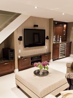 a living room filled with furniture and a flat screen tv mounted to the wall over a fireplace