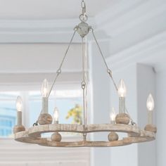 a chandelier hanging from the ceiling in a room with white walls and windows