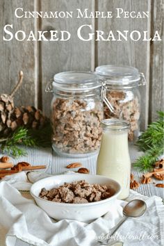 a bowl of cereal sitting on top of a table next to two glass jars filled with milk