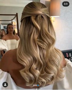 the back of a woman's head with long blonde hair styled into a half - updo