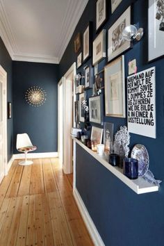 the hallway is decorated in blue and white with pictures on the wall, framed by frames