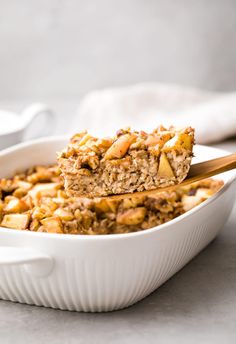 a white bowl filled with granola and topped with a wooden spoon on top of it