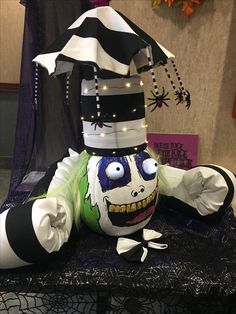 a creepy looking stuffed animal sitting on top of a black and white cloth covered table