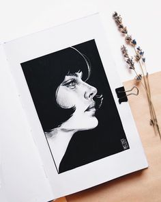 an open book with a drawing of a woman's face