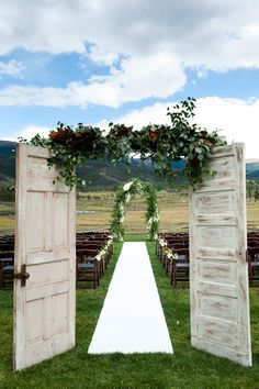 an open door leading to a wedding ceremony with greenery on the top and bottom