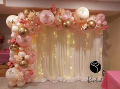 a balloon arch with pink and gold balloons