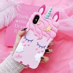 a woman holding a pink phone case with a unicorn on it