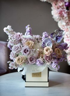 a vase filled with lots of purple and white flowers