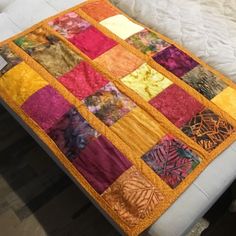 a bed with a quilt on top of it