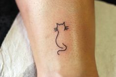 a small cat tattoo on the ankle